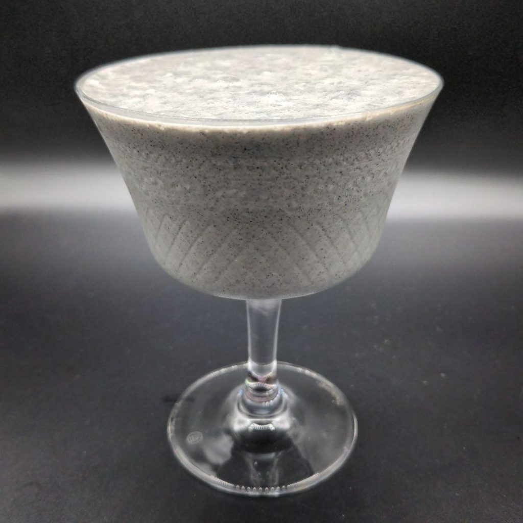 A fancy cocktail glass filled with thick concrete-gray liquid